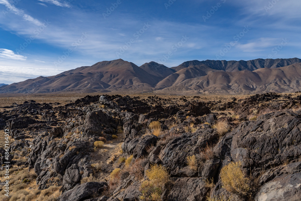 Obraz premium Volcanic rock, Basalt flows. Fossil Falls Trail, Coso Volcanic Field, Inyo County, California. Coso Range, Basin and Range Province. In the distance is Sierra Nevada ( mountain range )