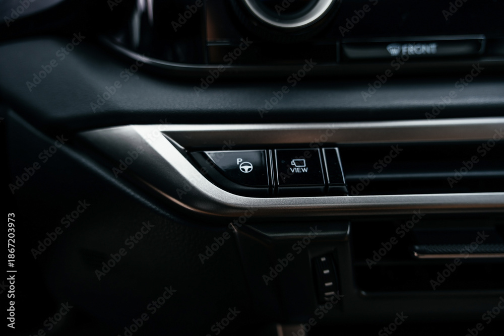 Fototapeta premium A premium, modern brown car interior, leather steering wheel, large navigation screen, air ducts, deflectors on the car panel. Interior details.