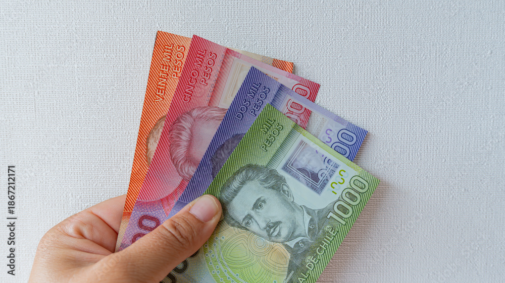 Φωτογραφία Hand holding colorful chilean peso banknotes, representing local economy, paymen