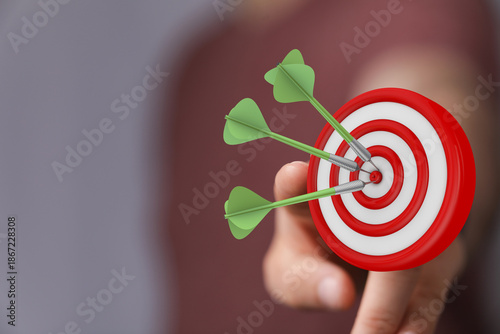 Hand holding a dartboard wi...