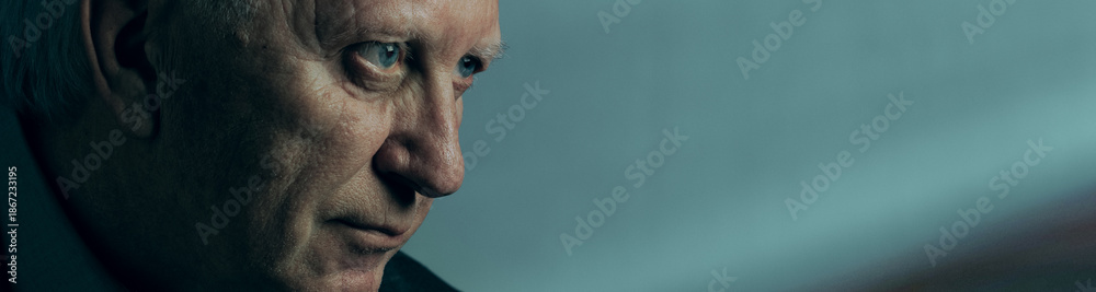 Obraz premium Intense close up of mature man with focused expression. Concept of critical thinking, emotional control, leadership pressure and decisive moments in business and management advertising. Banner