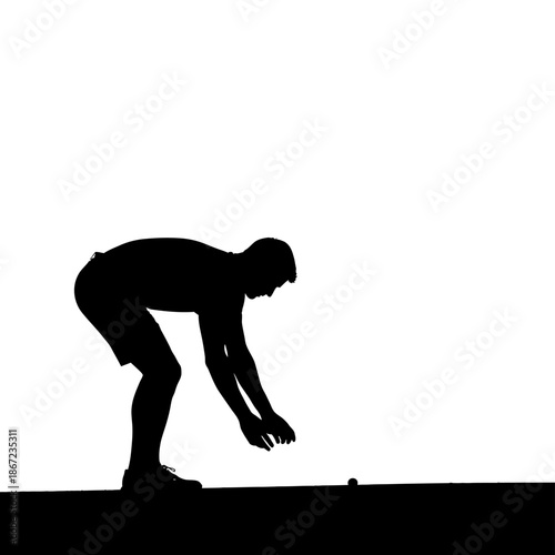 Silhouette of a man bending over to pick something up.