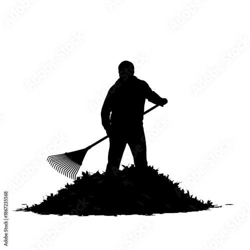 Silhouette of a man raking leaves into a pile.