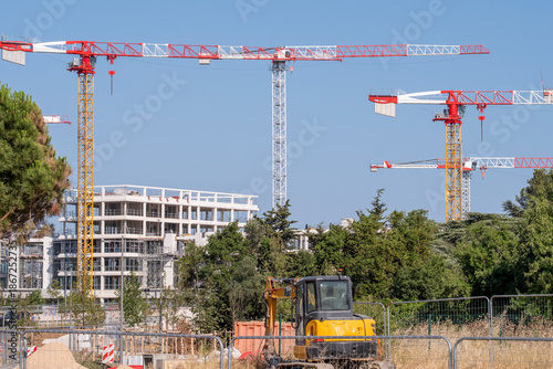 Wide view of construction site with tower crane over building development featuring architecture and urban engineering infrastructure for property project