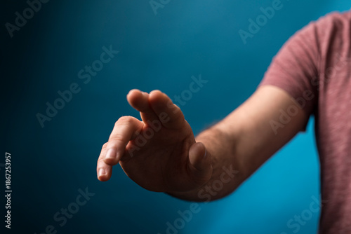 Fotografie Close-up of a man's hand gesturing, shot with a shallow depth of field against a