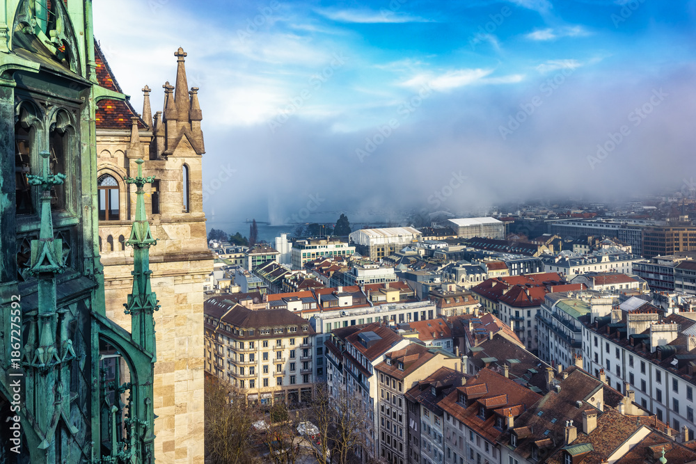 Obraz premium Elevated view from the Saint Pierre Cathedral in Geneva, Switzerland, of the city skyline during a foggy winter day with sunshine
