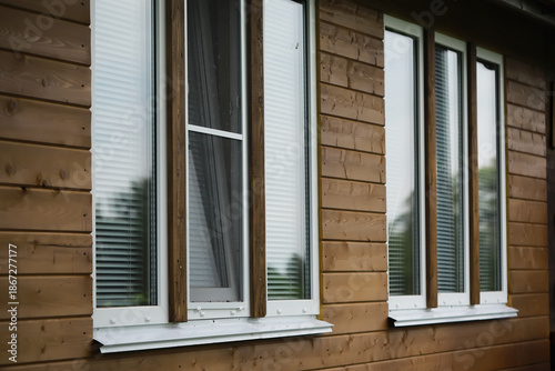Bilde på lerret Wooden House Facade with Multiple Windows Featuring Blinds and Reflective Glass