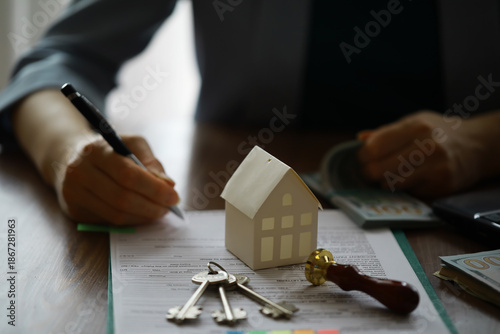 Real estate agent talked the terms of the home purchase agreement and asked the customer to sign the documents, Home sales and insurance concept. © alexkich