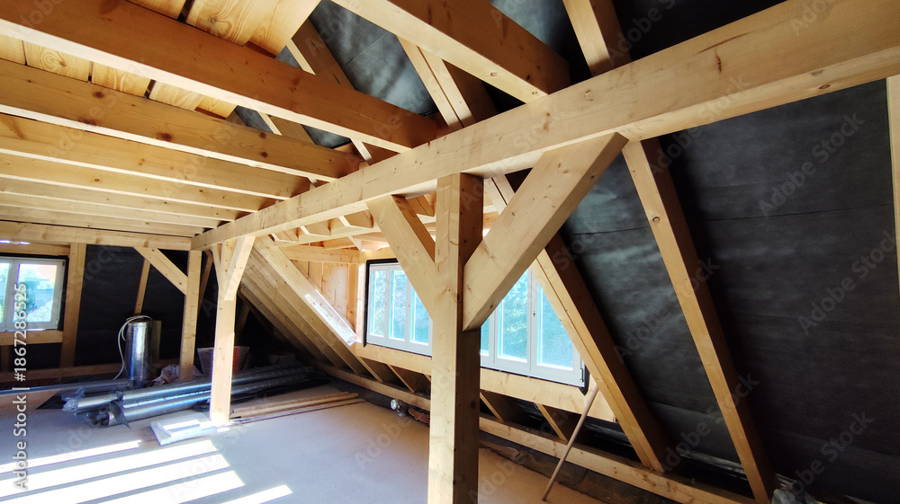 Fototapeta premium The attic of a house with wooden beams and roof coverings, inside the building.