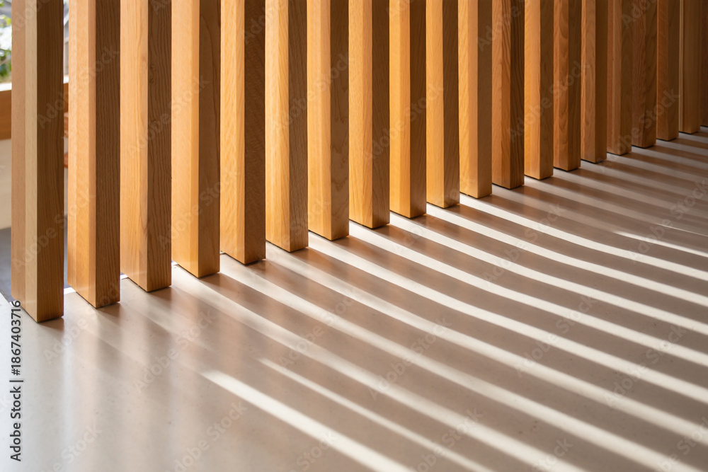 Obraz premium Sunlight casting shadows through vertical wooden slats