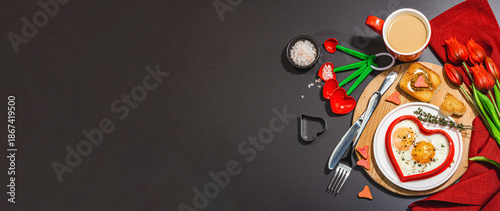 Heart-shaped fried egg served with toasted bread. Romantic art food idea for Valentine's breakfast