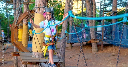 Child Enjoying Adventure Park Rope Course in Forest Setting