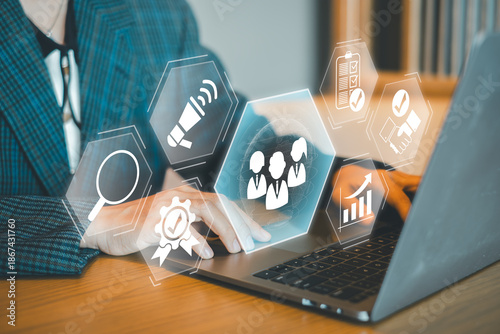 Business professional working on a laptop with digital marketing and data analysis icons overlay, symbolizing modern technology.