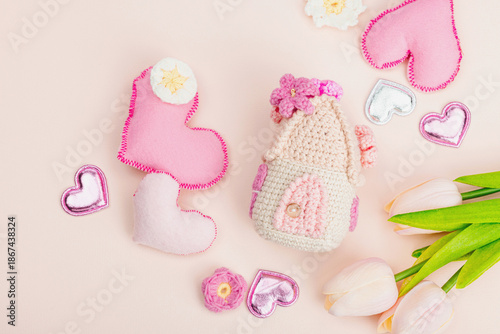 Handmade Valentines Day concept. Creative spring crocheting, house figurine, flowers and hearts
