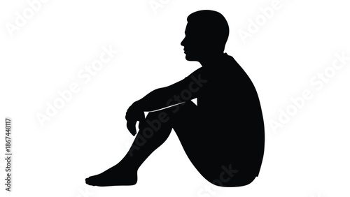Silhouette of a man sitting with knees drawn up to his chest
