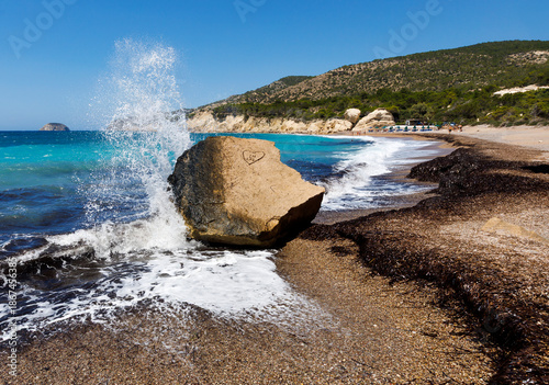 Fale rozbijające się o skałę na dzikiej plaży w Grecji – turkusowe morze i malownicze wybrzeże Rodos