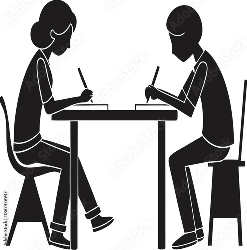 Two students studying together at a table with books and pens