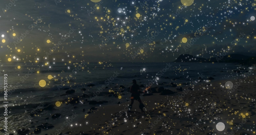 Fototapeta premium Walking dark figure along sandy shore at dusk, wearing dark coat and bag amid bokeh overlay