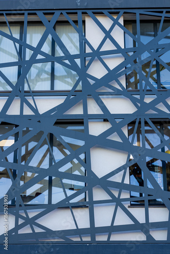 Vue d’une devanture de bâtiment avec des éléments en métal bleu, mettant en valeur une façade architecturale moderne aux lignes industrielles et aux couleurs contrastées.