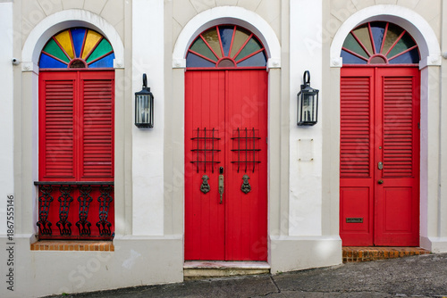 Three old vibrant red doors with stained glass windows