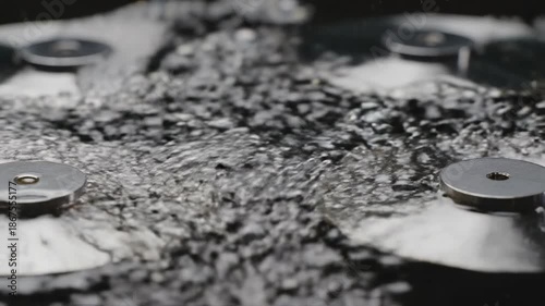 Wallpaper Mural Abstract macro shot of rapidly rising effervescent bubbles surrounding reflective metallic discs spinning on a dark liquid surface generating powerful waves bubbles, hypnotic, rotating Torontodigital.ca