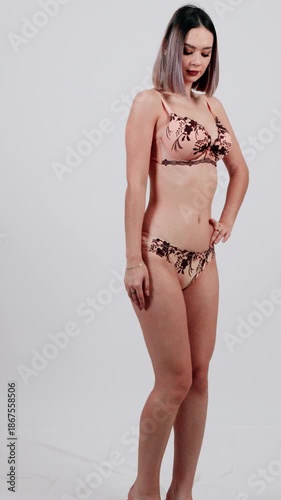 Woman in animal print lingerie set on white background.