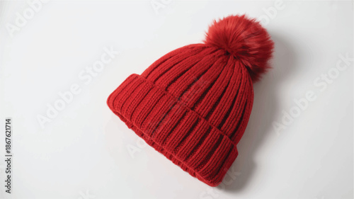 red knit beanie with pom pom on white surface