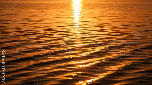 Golden sunset over calm ocean waves.