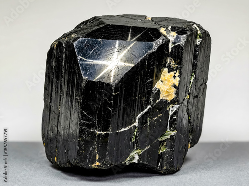 A collectible geological specimen of polished black star diopside with a four rayed asterism effect.