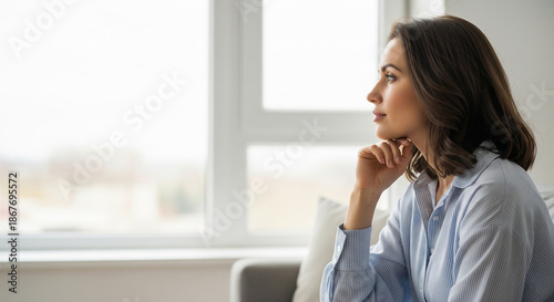 A pensive woman looking out the window with hand on chin, perfect for future planning, contemplation, and quiet moments Free Download A pensive woman looking out the window with hand on chin, perfect for future planning, contemplation, and quiet moments - GFXLoad