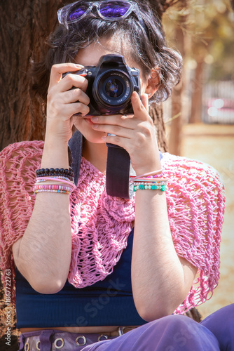 Latina teenager taking happy outdoor photos on a sunny day, perfect image to commemorate