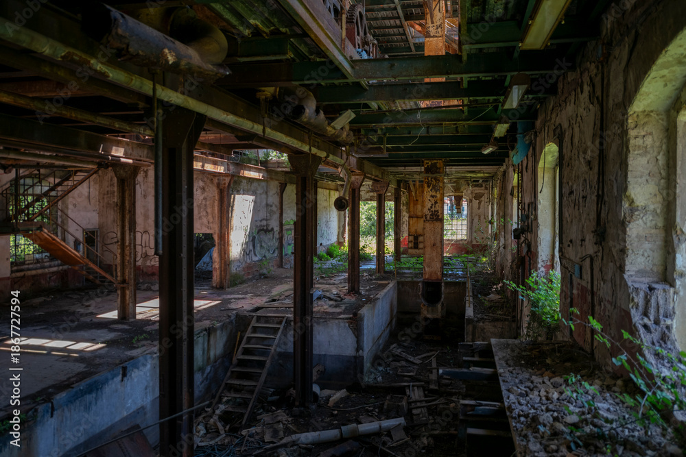 Fototapeta premium Abandoned sugar factory in Italy. Industrial ruins, derelict refinery interior, and urban exploration (urbex) photography