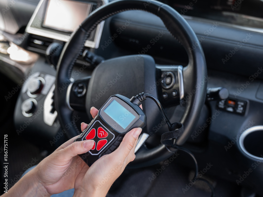 Fototapeta premium Woman using OBD2 diagnostic scanner. 