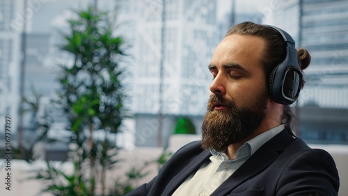Foto Male leader relaxes during a work break using sound healing to reduce stress