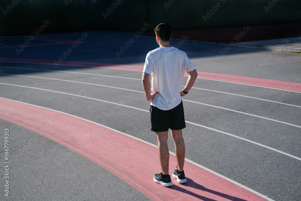 Obraz premium Young man preparing for a run on an outdoor athletics track. unrecognizable person