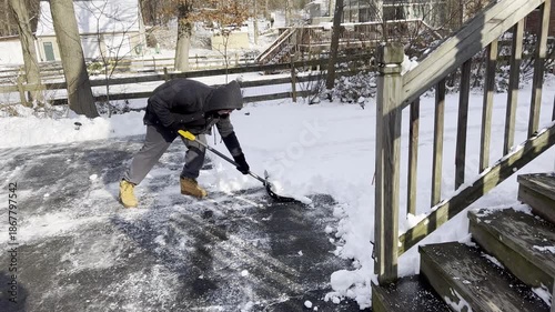 young man shoveling the driveway after snow storm in January in New Jersey