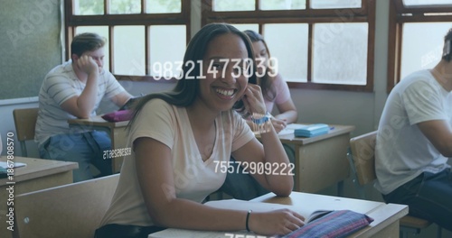 Quadro su tela Smiling student wearing top, leaning on hand in class, showing notebook, pencil