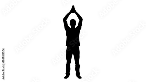 Silhouette of a man standing with his arms raised above his head in a yoga pose on a for meditation and relaxation