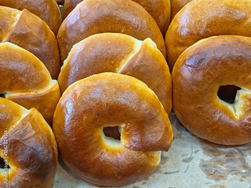 Fotografija Close-up view of several freshly baked, golden-brown plain bagels arranged together