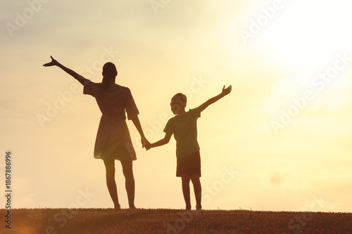 фотографія Mother, child holding hands walking in park in the morning sunshine, Family supp