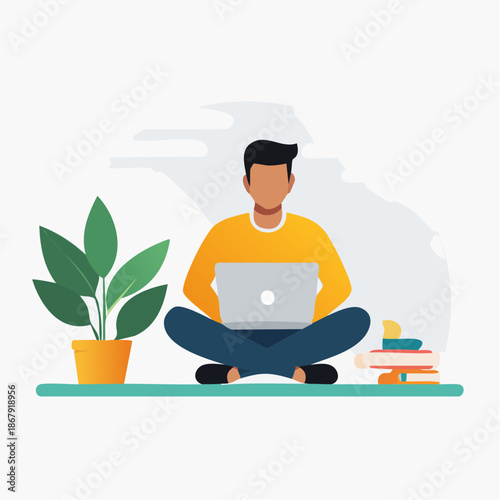 Man sitting cross-legged using laptop with potted plant and books nearby