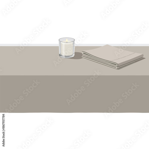 A minimalist still life featuring a lit candle in a glass holder and folded beige fabric on a taupe tablecloth.
