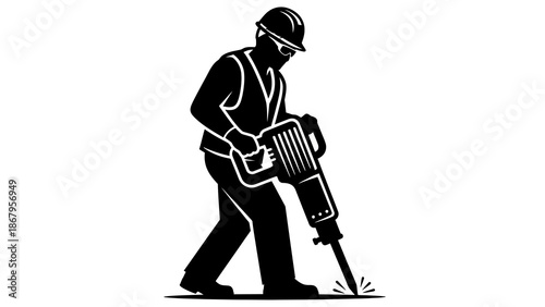 Construction worker operating a jackhammer on the ground with safety gear