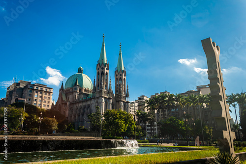 Sao Paulo, Brazil. May 16, 2012. The Marco Sincrético da Cultura Afro-Brasileira by Rubem Valentin, honoring Afro-Brazilian heritage, stands before the iconic Sé Cathedral, symbolizing syncretism.