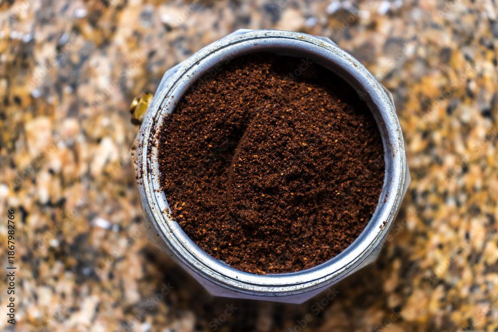 custom made wallpaper toronto digitalOverhead close-up of a classic Italian moka pot funnel filled with freshly ground coffee powder, ready for brewing on a granite countertop. A symbol of traditional, homemade espresso.
