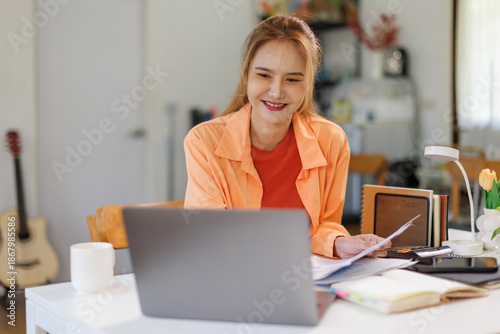Portrait of female freelancer working with a large number of documents, searching for documents, accounting of income and expenses, tax records and checking documents on a desk .
