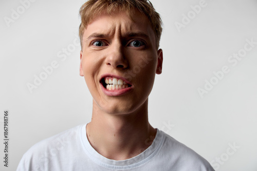 Photos Closeup of an angry, frustrated man with clenched teeth and wide eyes, conveying