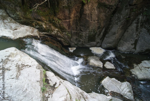 岩壁の仏像と流れ落ちる小川の風景