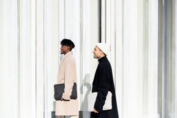 Confident colleagues in business attire walking by modern building in Barcelona