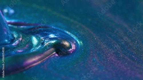 Mesmerizing macro photograph captures the swirling iridescent texture of deep blue and teal viscous liquid showcasing subtle glitter particulate creating an abstract dynamic background surface.